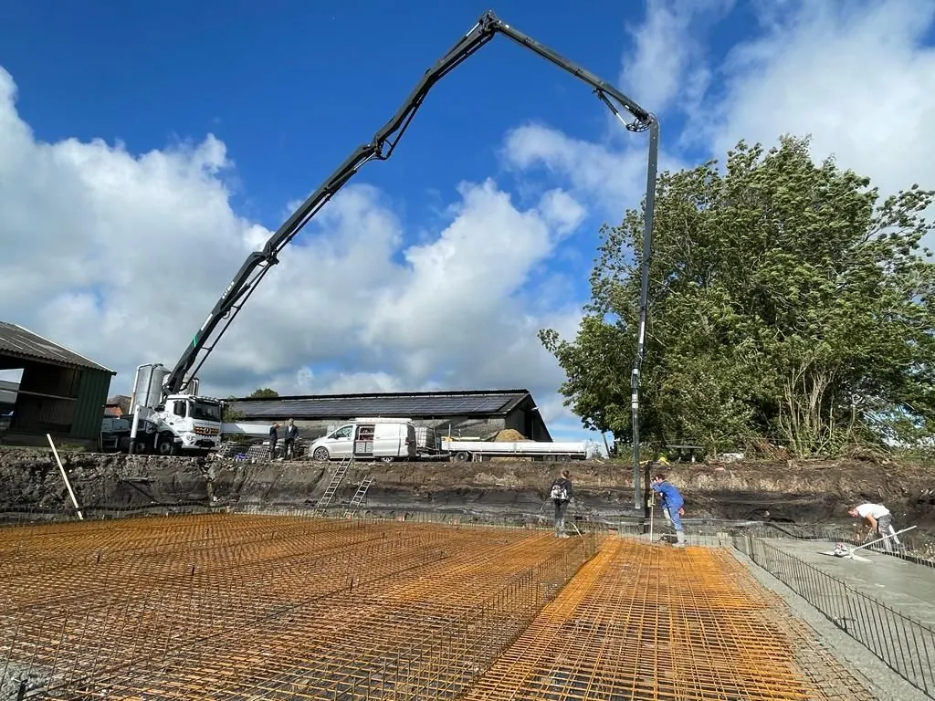 Schwing 47m betonpomp boven een bouwplaats
